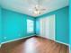 Bright bedroom featuring sleek wood-look flooring, a ceiling fan, and a spacious closet at 11744 Oswalt Rd, Clermont, FL 34711