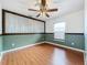 Bedroom featuring wood floors, a decorative accent wall, and natural lighting from a window at 11744 Oswalt Rd, Clermont, FL 34711