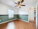 Bedroom with wood floors, accent wall, ceiling fan, and natural light at 11744 Oswalt Rd, Clermont, FL 34711