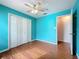 Bedroom featuring wood-look flooring, a ceiling fan, a spacious closet, and a doorway to another room at 11744 Oswalt Rd, Clermont, FL 34711