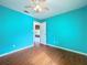 Bedroom with wood-look flooring, a ceiling fan, and an open doorway leading to another room at 11744 Oswalt Rd, Clermont, FL 34711