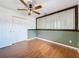 Bedroom featuring wood-look flooring, ceiling fan, closet, and a decorative corrugated metal accent piece at 11744 Oswalt Rd, Clermont, FL 34711