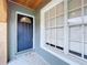 Inviting covered front porch featuring a painted front door and a large window with natural light at 11744 Oswalt Rd, Clermont, FL 34711