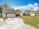 Inviting front yard view of this one-story home, showcasing the driveway, garage, and green space at 11744 Oswalt Rd, Clermont, FL 34711