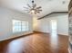 Open living room with stylish ceiling fan, wood-look floors, and a view into the bathroom at 11744 Oswalt Rd, Clermont, FL 34711