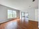 Open living room with wood-look flooring, light grey walls, and access to a screened-in porch at 11744 Oswalt Rd, Clermont, FL 34711