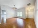 Spacious living room with wood-look flooring, a ceiling fan, and natural light, creating a welcoming atmosphere at 11744 Oswalt Rd, Clermont, FL 34711