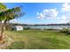 Backyard featuring green grass, a shed, a palm tree and the beautiful waterfront at 1320 Cove Pl, Tavares, FL 32778