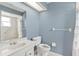 Bathroom with blue walls, shower, sink, and toilet at 1320 Cove Pl, Tavares, FL 32778