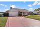 Well-maintained home featuring an attached garage, brick facade, manicured lawn, and inviting front entrance at 1320 Cove Pl, Tavares, FL 32778