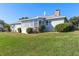 Single-story home showcasing a well-maintained lawn, a sunroom with multiple windows, and mature landscaping at 1320 Cove Pl, Tavares, FL 32778