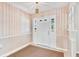 Inviting foyer featuring a white door with sidelights, a neutral rug, and elegant wallpaper at 1320 Cove Pl, Tavares, FL 32778