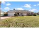 Charming single-story home featuring a well-manicured lawn, brick accents, attached garage, and inviting front porch at 1320 Cove Pl, Tavares, FL 32778