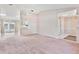 Bright and airy living room featuring carpet flooring and seamless connection to other living spaces at 1320 Cove Pl, Tavares, FL 32778