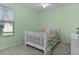 Charming bedroom with light green walls, white furniture, and a comfortable bed at 13914 Se 96Th Cir, Summerfield, FL 34491