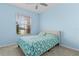 Cozy bedroom featuring light blue walls, a comfortable bed, and a window with a view at 13914 Se 96Th Cir, Summerfield, FL 34491