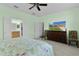 Main bedroom with green walls and carpet with views to the main bathroom and a large television at 13914 Se 96Th Cir, Summerfield, FL 34491