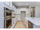 White kitchen with stainless steel appliances and quartz countertops at 14261 Crest Palm Ave, Windermere, FL 34786