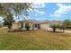 Tan single-story house with a gray roof, landscaping, and a two-car garage at 1514 Vandam St, The Villages, FL 32162