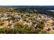 Expansive aerial view of a community nestled among lush greenery, with homes lining winding streets and near a lake at 1617 Myrtle Lake Ave, Fruitland Park, FL 34731