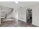 Sunlit living room featuring wood-style flooring, an arched doorway, and an open staircase at 1617 Myrtle Lake Ave, Fruitland Park, FL 34731