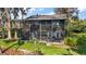 View of home's screened in porch, walkway, and meticulous lawn and landscaping at 1702 N County Road 452, Eustis, FL 32726