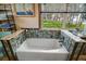 Bathroom with a large tub and tiled backsplash; view of nature through the window at 1702 N County Road 452, Eustis, FL 32726