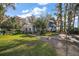 Charming two-story home with manicured lawn, mature trees, and outdoor walkway at 1702 N County Road 452, Eustis, FL 32726