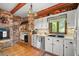 Charming kitchen with white cabinets, a brick oven, and natural light from the window at 1702 N County Road 452, Eustis, FL 32726