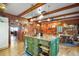 Charming kitchen with a green island, wooden beams, and rustic wood-paneled walls at 1702 N County Road 452, Eustis, FL 32726