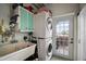 Functional laundry room featuring stacked washer and dryer, utility sink, and ample cabinet space at 1702 N County Road 452, Eustis, FL 32726