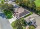 Expansive aerial view of a single-story home featuring a well-manicured lawn, mature trees, and a long concrete driveway at 17180 Se 115Th Terrace Rd, Summerfield, FL 34491