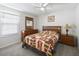 Bedroom featuring a bed with quilt, dresser with mirror, ceiling fan and side table at 17180 Se 115Th Terrace Rd, Summerfield, FL 34491