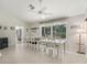 Well-lit dining room with large windows, ceiling fan, and a view of the backyard at 17180 Se 115Th Terrace Rd, Summerfield, FL 34491