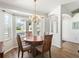 Bright dining room featuring a round wooden table, chandelier lighting, and neutral color scheme at 17180 Se 115Th Terrace Rd, Summerfield, FL 34491