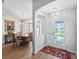 Welcoming entryway with hardwood floors leading to the dining room and a view of the front door at 17180 Se 115Th Terrace Rd, Summerfield, FL 34491