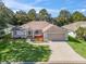 Charming single-story home with well-manicured lawn, long driveway, and a beige two-car garage at 17180 Se 115Th Terrace Rd, Summerfield, FL 34491