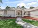 Inviting front entrance with double glass doors, manicured lawn, and a welcoming walkway at 17180 Se 115Th Terrace Rd, Summerfield, FL 34491