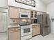 Bright kitchen with white appliances and neutral-toned cabinets at 17180 Se 115Th Terrace Rd, Summerfield, FL 34491