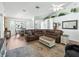 Open-concept living room with a vaulted ceiling, leather sofa, and views into the dining area at 17180 Se 115Th Terrace Rd, Summerfield, FL 34491