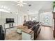 Spacious living room featuring a leather sofa, ceiling fan, and hardwood flooring at 17180 Se 115Th Terrace Rd, Summerfield, FL 34491