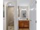 En-suite bathroom featuring a glass-enclosed shower, wood vanity, and modern lighting fixtures at 17457 Se 121St Cir, Summerfield, FL 34491