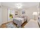 Comfortable bedroom with natural light from the window, ceiling fan, and a decorative rug on the floor at 17457 Se 121St Cir, Summerfield, FL 34491