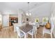 Bright dining area featuring modern decor, wood floors, an elegant chandelier, and an open floor plan at 17457 Se 121St Cir, Summerfield, FL 34491