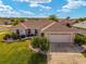 Aerial view of a well-maintained home showcasing front yard landscaping and an attached two-car garage at 17457 Se 121St Cir, Summerfield, FL 34491