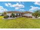 Charming single-story home with lush green lawn, mature palm trees, and meticulous landscaping for enhanced curb appeal at 17457 Se 121St Cir, Summerfield, FL 34491