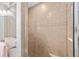 The walk-in shower features neutral tile, a built in seat, and a decorative strip, and a clear glass partition at 17457 Se 121St Cir, Summerfield, FL 34491