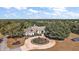 Aerial view of stunning property with circular driveway, mature trees, and meticulously landscaped grounds at 1825 Myrtle Lake Ave, Fruitland Park, FL 34731