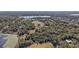 Wide aerial view of home in wooded area with lake view and surrounding neighborhood at 1825 Myrtle Lake Ave, Fruitland Park, FL 34731