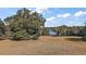 Expansive property showcasing mature trees and a vast, open field leading up to a lake at 1825 Myrtle Lake Ave, Fruitland Park, FL 34731